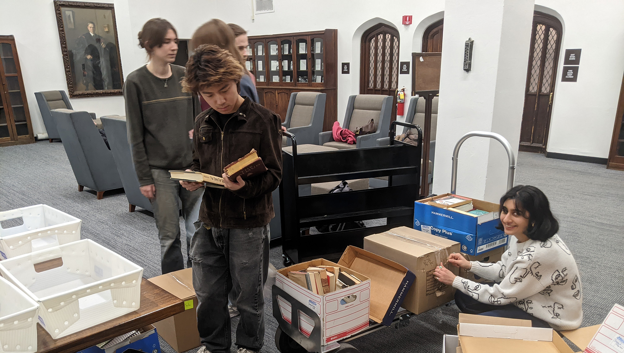 students standing around boxes of boxes sorting them into bins